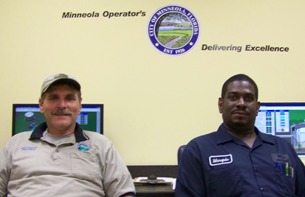 Wastewater Treatment Plant Operators Inside an Office Sitting Behind a Desk
